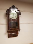 A 19th century walnut eight day wall clock with pendulum and key,