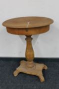An antique oak pedestal work table