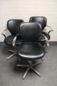 Three black vinyl and metal hydraulic barber's chairs