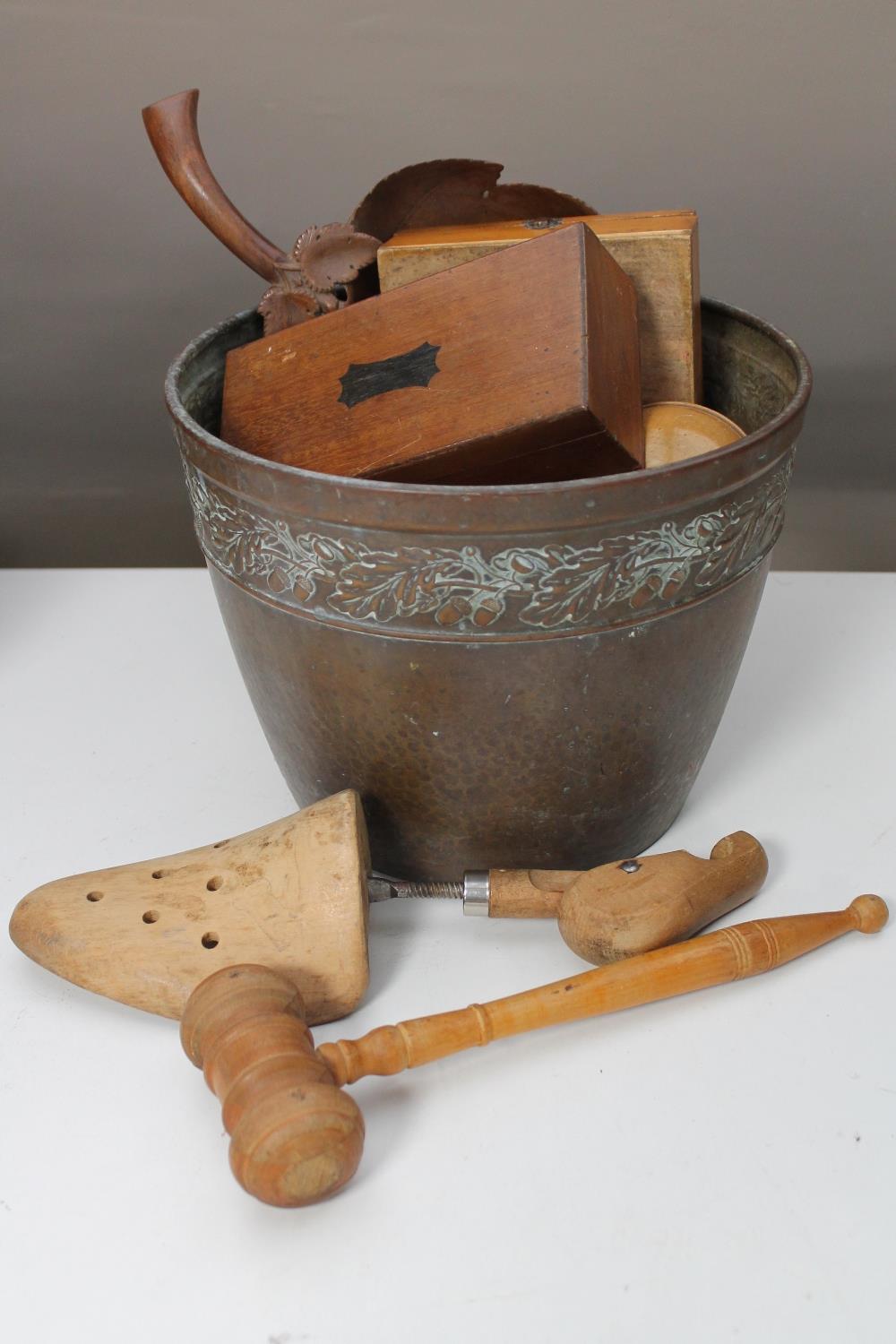 An antique copper bucket containing treen items - gavel, boxes,