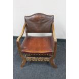 An early 20th century oak armchair upholstered in leather