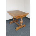 A 1930's oak turnover top dining table on carved supports