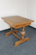 A 1930's oak turnover top dining table on carved supports