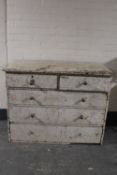 A painted antique pitch pine five drawer chest