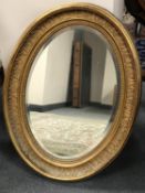 An antique gilt framed oval bevelled mirror