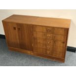 A mid twentieth century Danish teak double door cabinet with matching five drawer chest