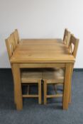 An oak extending dining table and four chairs