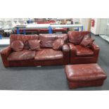 A tan leather two seater settee with matching armchair and footstool plus four scatter cushions