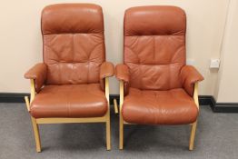 A pair of beech framed brown leather adjustable armchairs