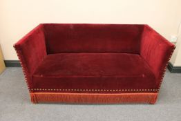 A twentieth century two seater hall settee upholstered in a red dralon