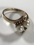 A 9ct gold ring set with two pearls and six small garnets, 3.6g, size O.