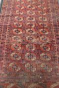 A fringed Persian rug on red ground,
