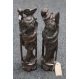 A pair of Oriental intricately carved wooden figures modelled as two village elders,