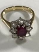 An 18ct gold ruby and diamond cluster ring, approximately 1ct, size N/O.