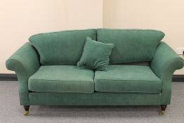 A two seater scroll arm settee upholstered in a green fabric