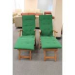 A pair of teak steamer garden armchairs with footrests and cushions