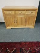 A contemporary light oak sideboard fitted three drawers,