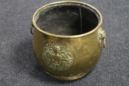 A 19th century brass embossed coal bucket with lion mask handles