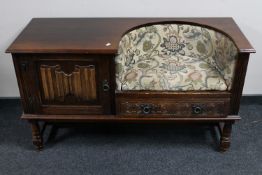 An oak linen fold telephone table fitted a cupboard and drawer