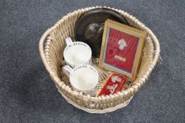 A wicker basket containing two Wedgwood Queen Elizabeth II commemorative tankards, plaque,