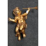 A gilt chalk figure of a cherub holding a trumpet,