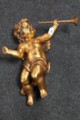 A gilt chalk figure of a cherub holding a trumpet,