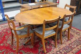 An inlaid yew wood dining table and six chairs