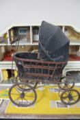 A mid 20th century doll's house together with a metal and wicker doll's pram