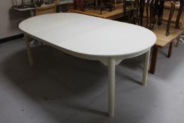 A white dining table with two extension leaves
