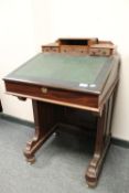 A Victorian mahogany Davenport, width 61 cm, with glass inkwells.