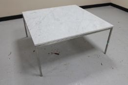 A square marble topped coffee table on metal legs