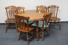 A circular kitchen table with leaf together with a set of six farmhouse style chairs