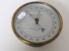 A circular brass cased aneroid barometer by T. A.