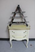 A white and gilt bedside chest and a triangular painted wall shelf
