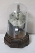 A Bulle electric clock under glass shade