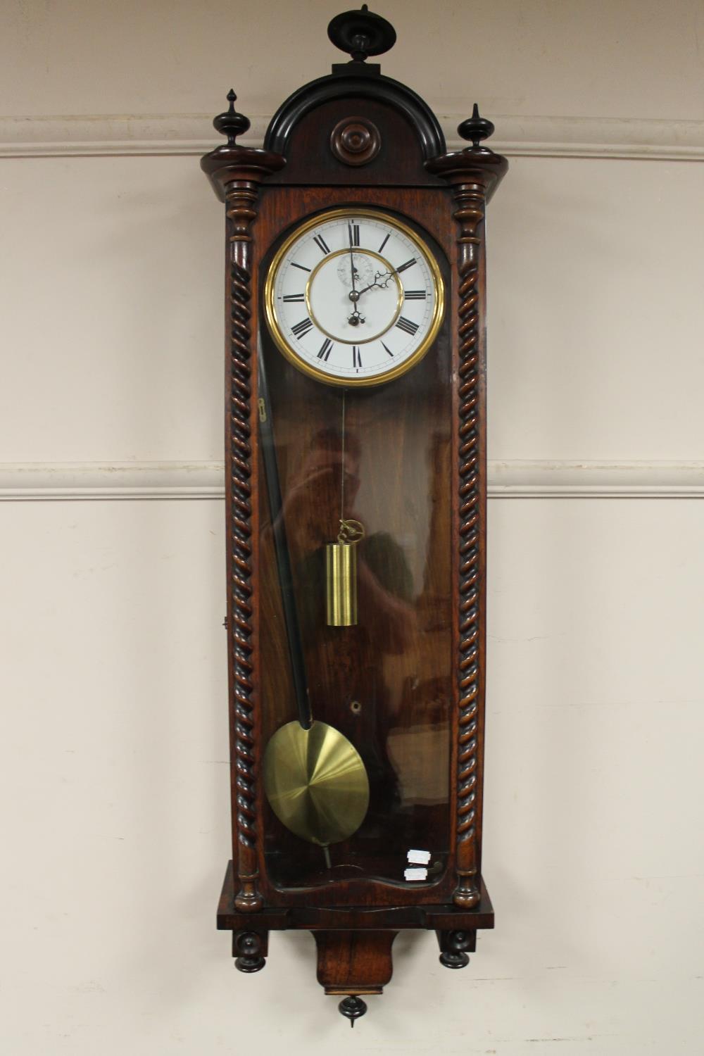 An early 19th century rosewood wall clock with pendulum, key and weight,