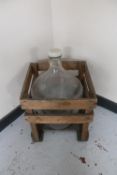 A carboy in wooden crate