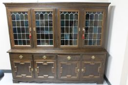 A continental oak four door dresser fitted cupboards and drawers beneath CONDITION