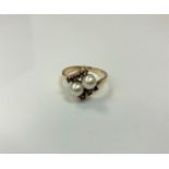 A 9ct gold ring set with two pearls and six small garnets, 3.6g, size O.