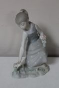 A Lladro figure of a girl picking flowers,