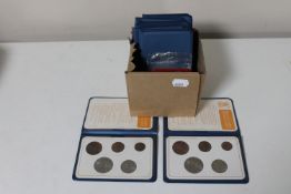 A box containing fourteen Britains first decimal coin sets in plastic wallets together with five