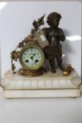 A continental gilt figural mantel clock of a cherub with enamelled dial on marble base