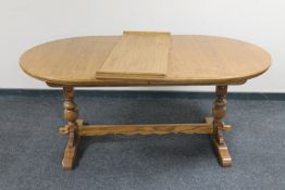 An oval oak refectory extending dining table