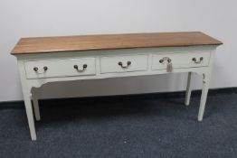 A pine three drawer hall table on painted base