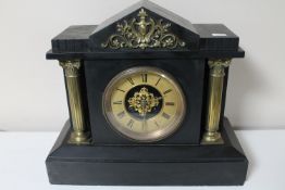 A Victorian black slate mantel clock with brass Corinthian column supports and brass dial