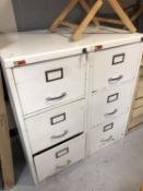 A pair of three drawer white metal filing cabinets