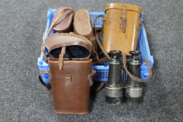 A basket containing five sets of binoculars in leather cases