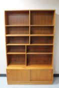 A Danish teak bookcase fitted with cupboards beneath