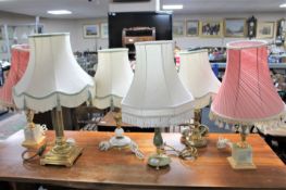 Three brass and onyx table lamps with shades together with a brass and marble table lamp with shade