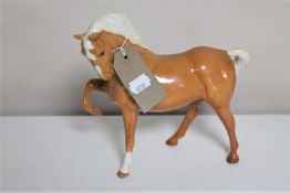 A Beswick horse figure - front foot raised